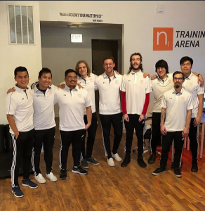 Ryan Kim (left) standing with his coaches at N1 Esports. 